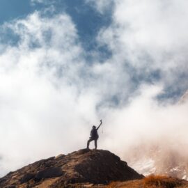 Young woman on top of a mountain celebrating