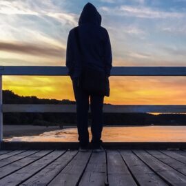 alone on a dock at sunset